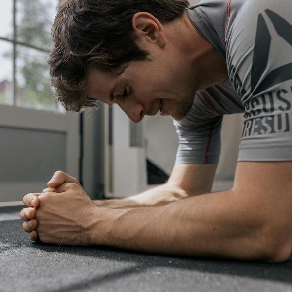 Man performing a plank with perfect form in a modern gym.